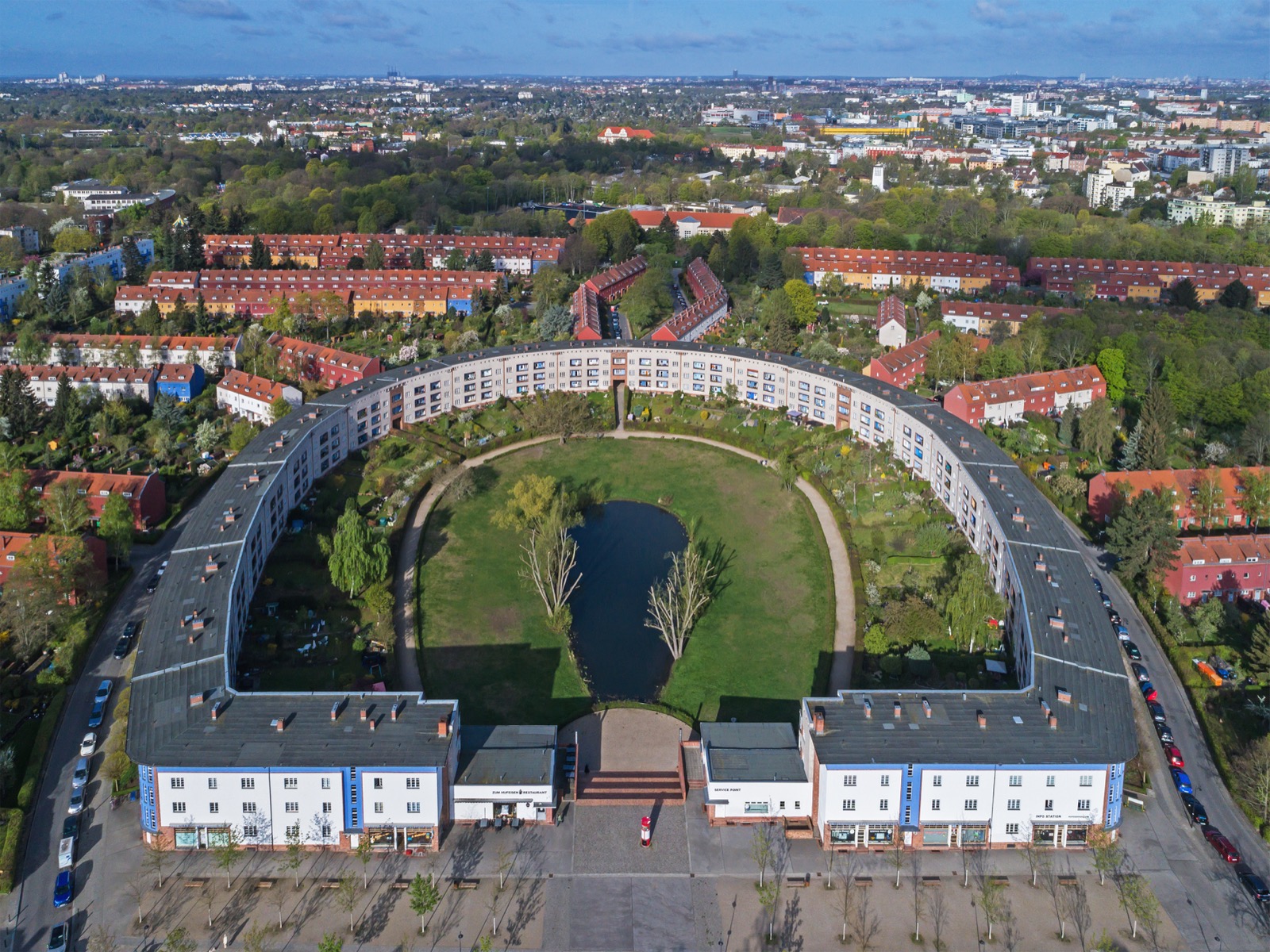 Luftaufnahme der Hufeisensiedlung in Berlin-Neukölln mit ihrer markanten hufeisenförmigen Wohnbebauung.