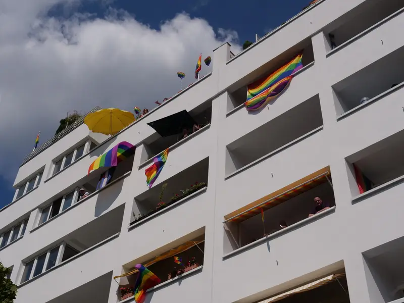 Menschen mit Regenbogenfahnen beim Christopher Street Day in Berlin
