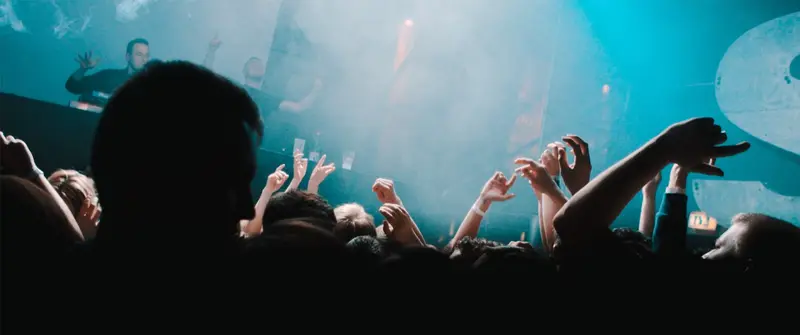 Tanzende Menge auf der Tanzfläche eines Nachtclubs bei Partylicht