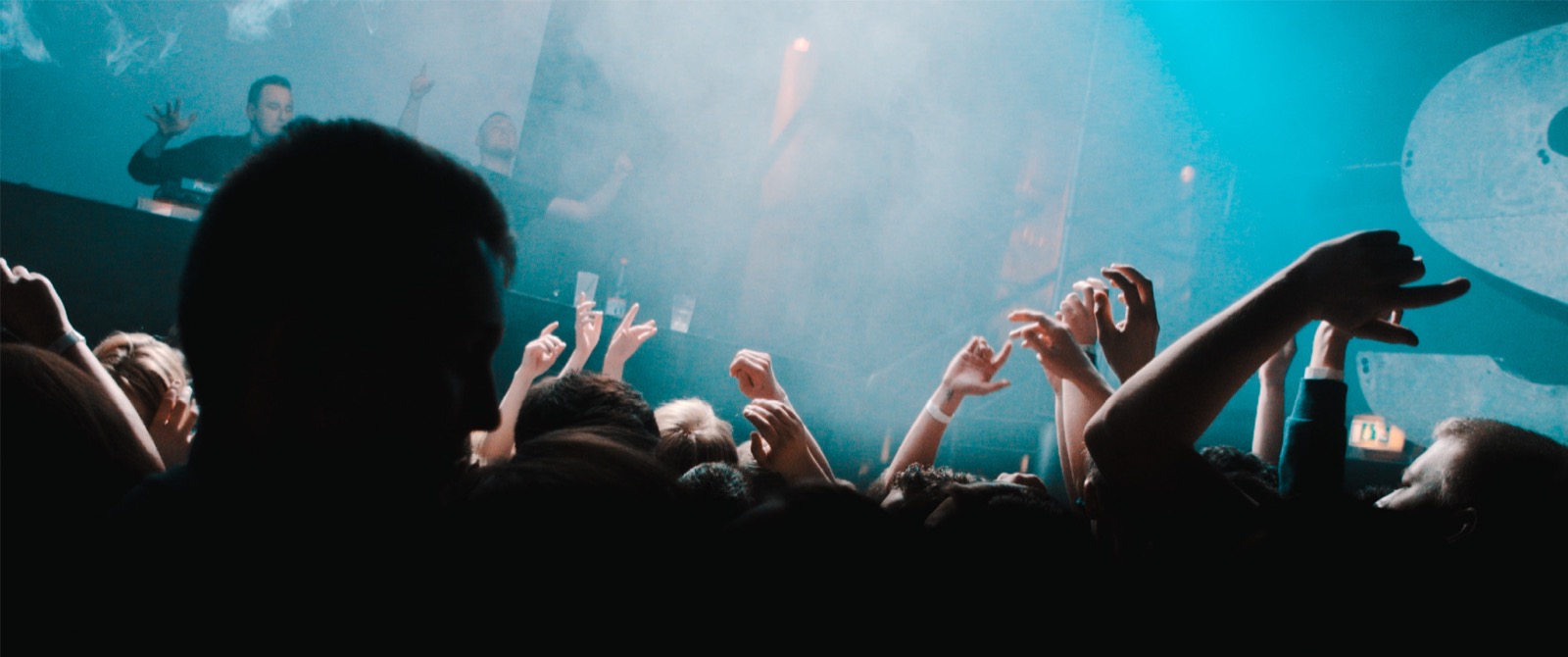 Tanzende Menge auf der Tanzfläche eines Nachtclubs bei Partylicht